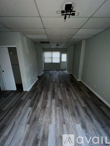 A room with wooden flooring and a ceiling fan.