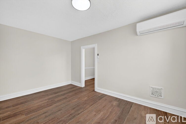 A room with a wooden floor and a white door.