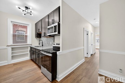 A kitchen with black cabinets and a white counter top.