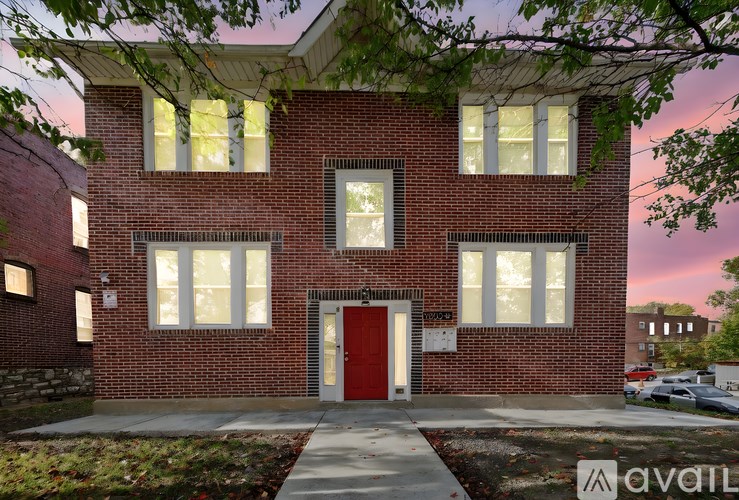 A red brick house with a red door and windows.