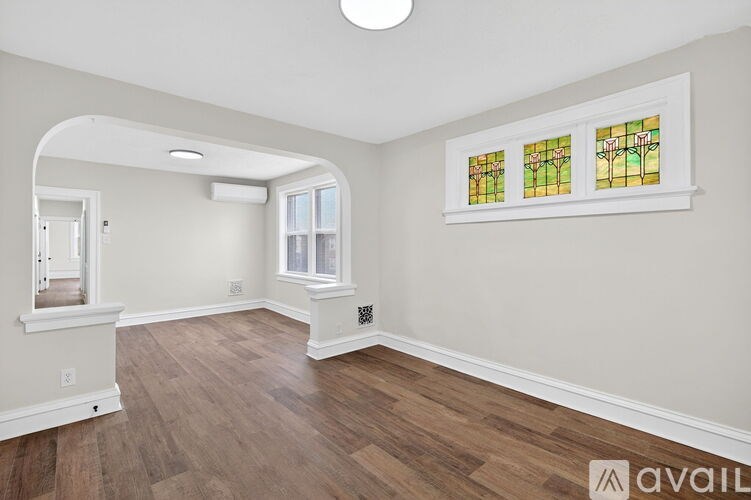 A room with wooden floors and a stained glass window.