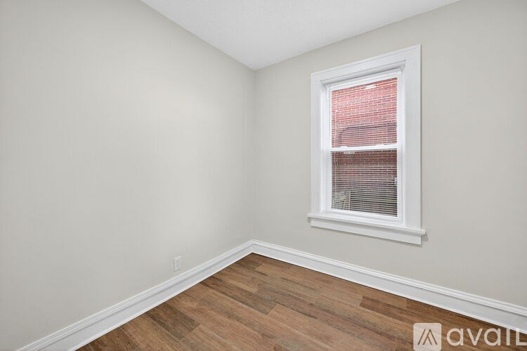 A room with a window and wooden flooring.