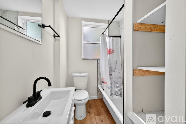 A bathroom with a sink, toilet, and a mirror.