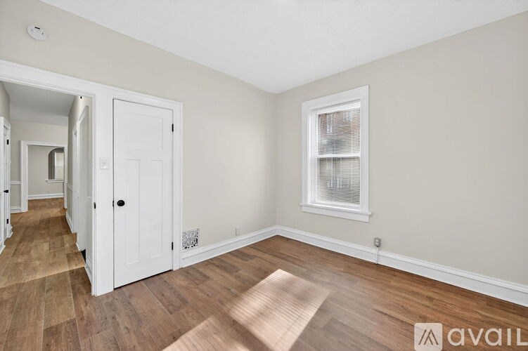 A room with a white door and a window with blinds.