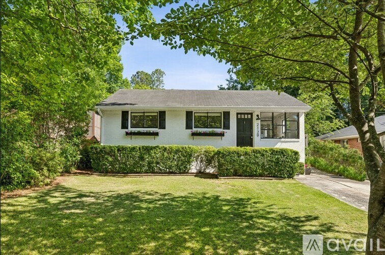 A white house with a green lawn in front.