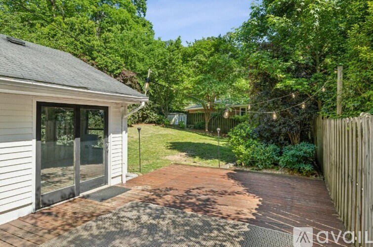 A backyard with a brick walkway leading to a white house.