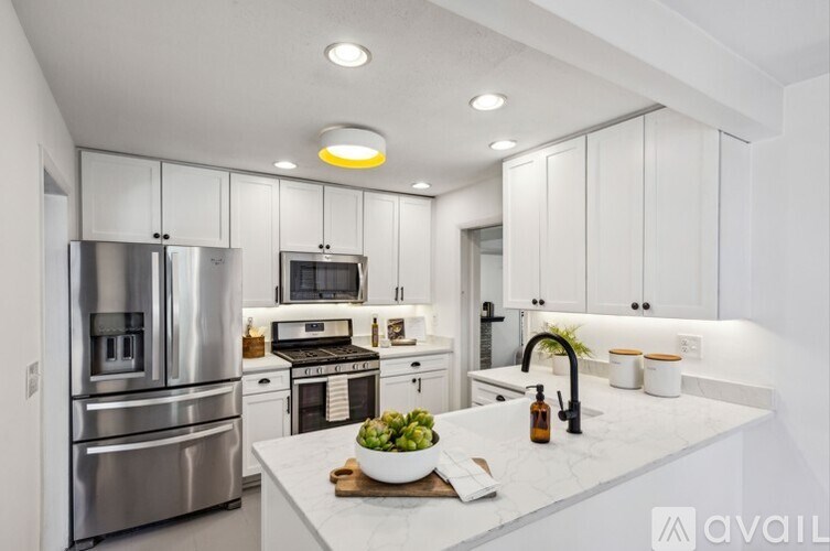 A modern kitchen with stainless steel appliances and white cabinets.