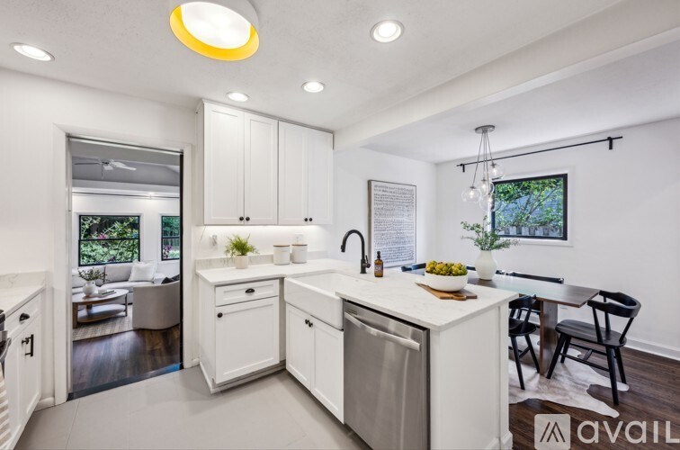 A modern kitchen with white cabinets and appliances.