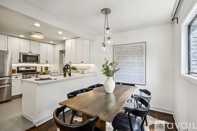 A modern kitchen with a wooden table and chairs.