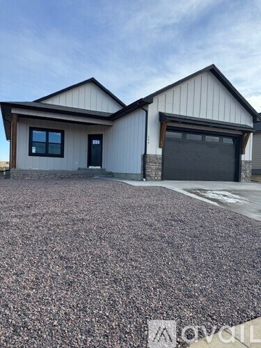 A house with a garage and a gravel driveway.