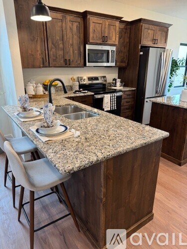 A kitchen with granite countertops and wooden cabinets.