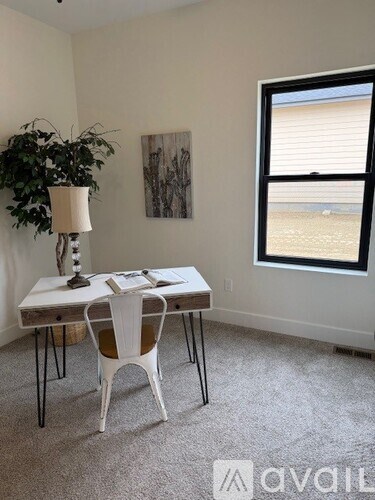 A room with a table, chairs, and a window.