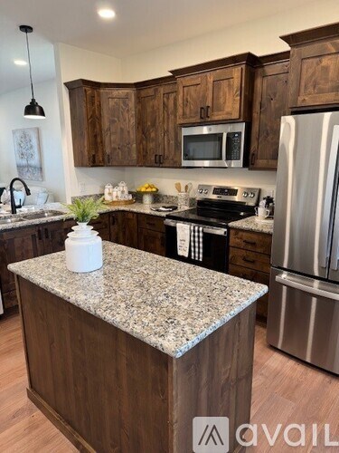 A kitchen with granite countertops and wooden cabinets.
