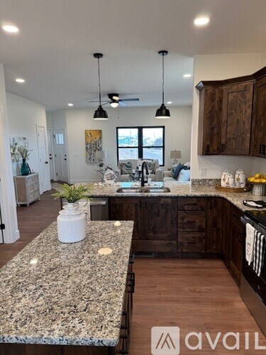 A kitchen with granite countertops and wooden cabinets.