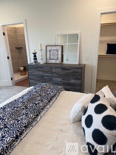 A bedroom with a bed, dresser, and mirror.