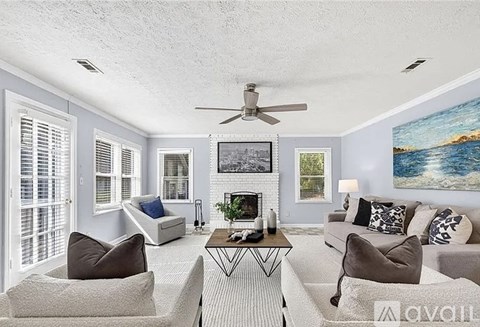 A living room with a fireplace, two chairs, and a coffee table.