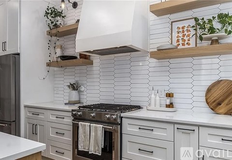 A modern kitchen with a black stove top oven and white countertops.