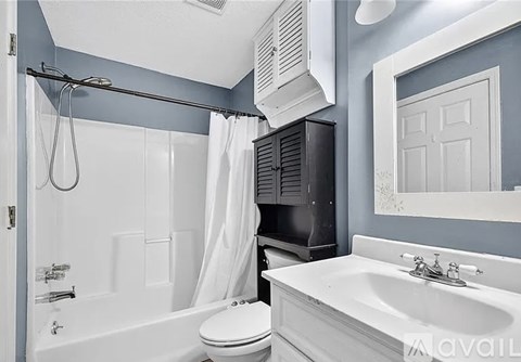 A bathroom with a white toilet, a white sink, and a white bathtub.