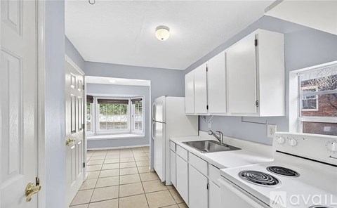A kitchen with white appliances and cabinets.
