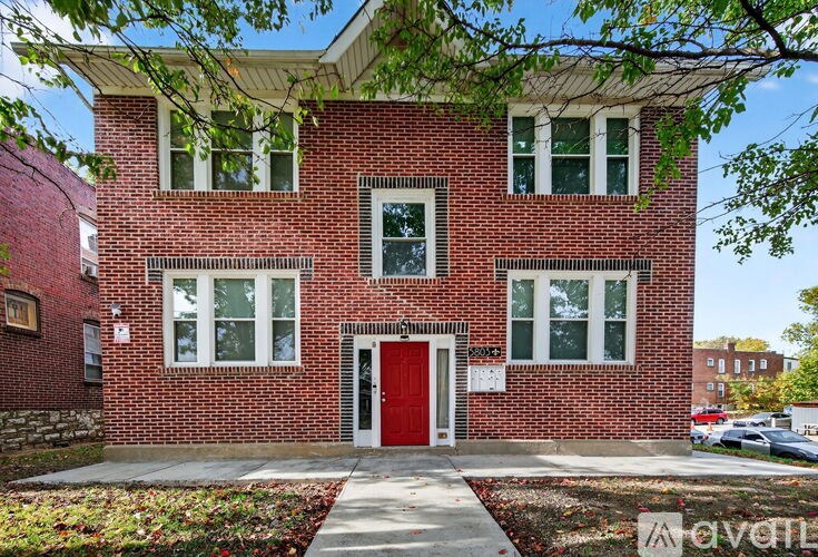 A red brick building with a red door and windows.