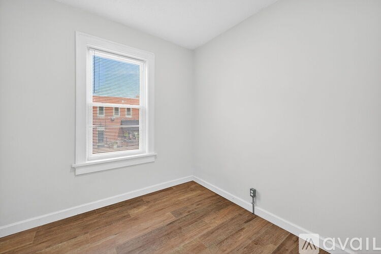 A room with a window and wooden flooring.