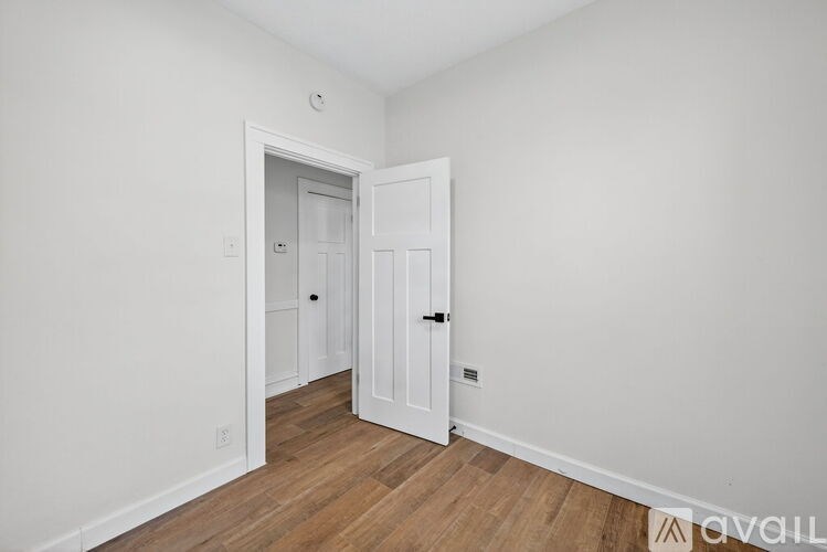 A room with a white door and a white wall.