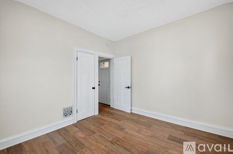 A room with two doors and a wooden floor.