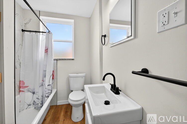 A small bathroom with a toilet, sink and a window.