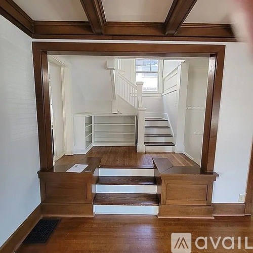 A wooden staircase with a landing and a wooden floor.