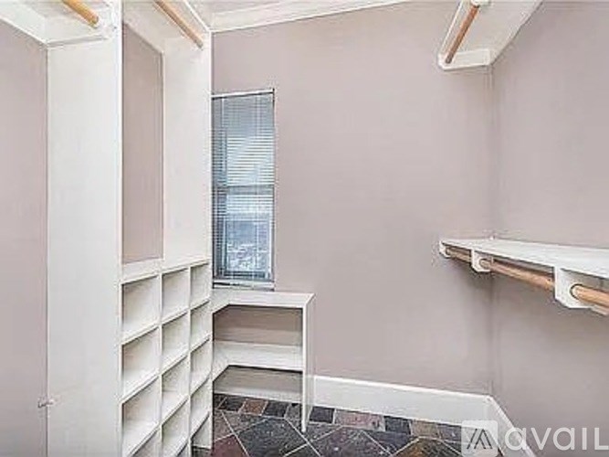 A room with a window and a shelving unit.