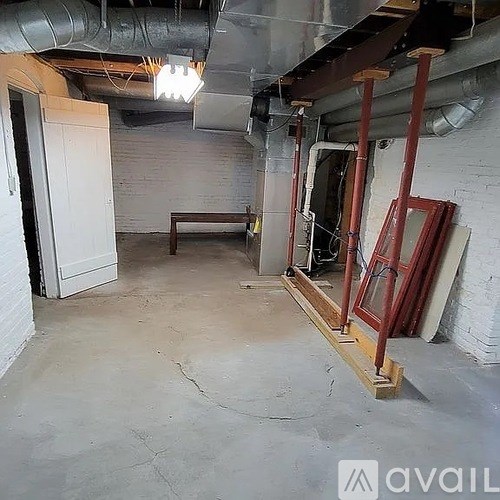 A room with a white door and a white wall with a window.