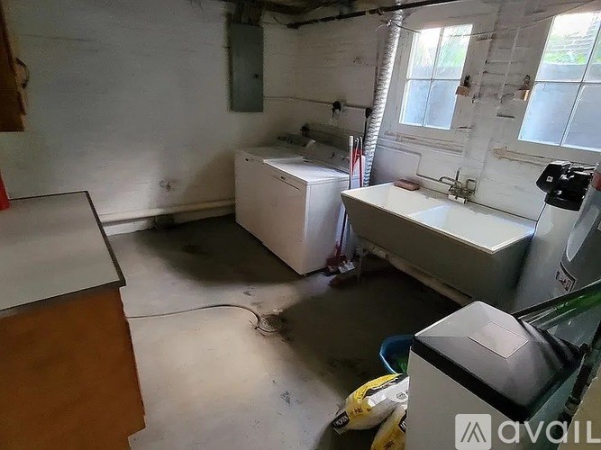 A dirty room with a sink and a window.