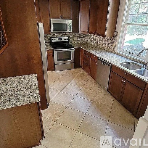 A kitchen with wooden cabinets and a granite countertop.
