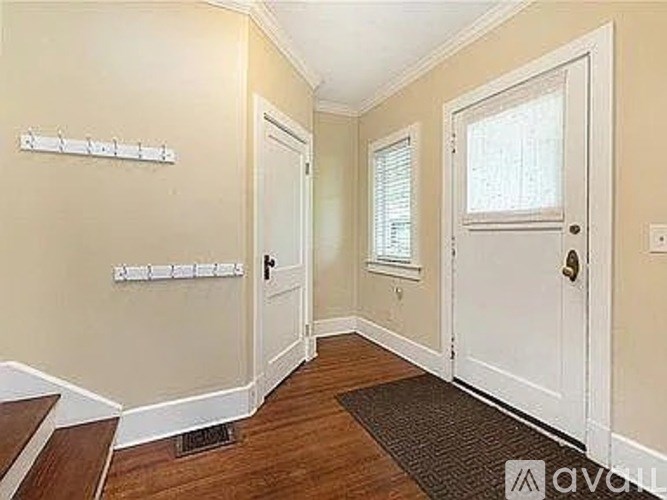 A hallway with a door on the right and a window on the wall.