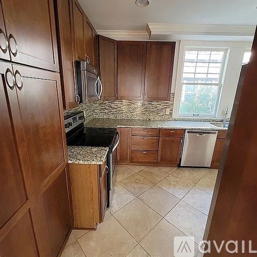 A kitchen with wooden cabinets and a granite countertop.