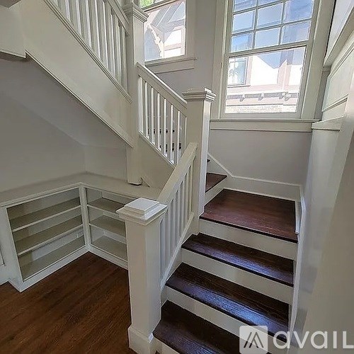A staircase with white railings and wooden steps.