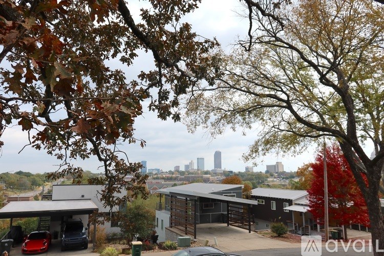 A view of a city skyline through trees with autumn leaves.