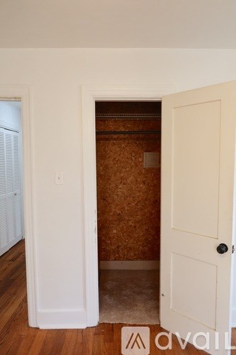 A white door is open to a room with brown walls.