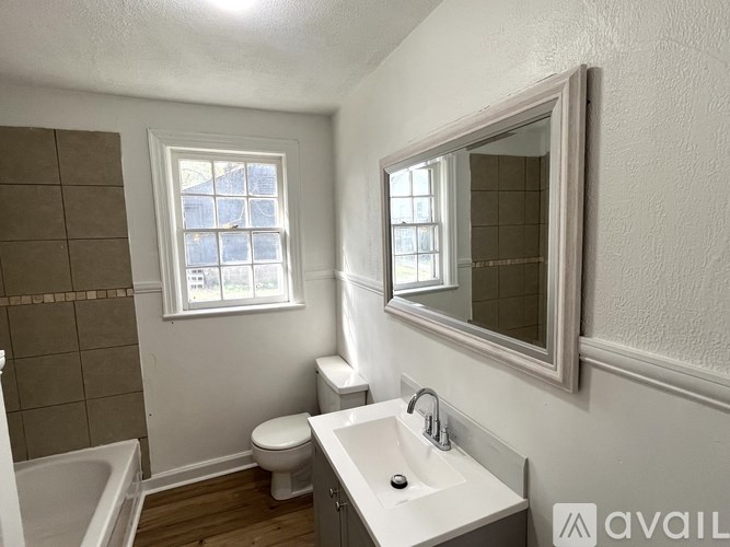 A bathroom with a toilet, sink, and tub.