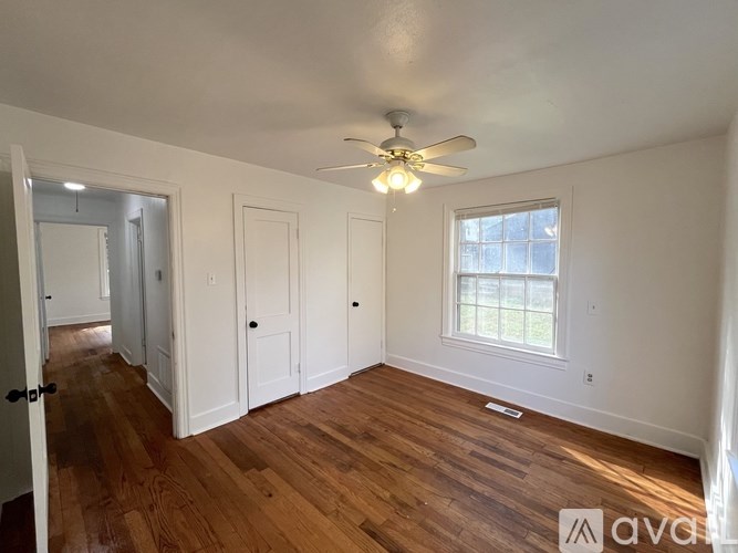 A room with a ceiling fan and a window.