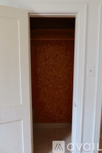 A white door is open to a room with brown wallpaper.