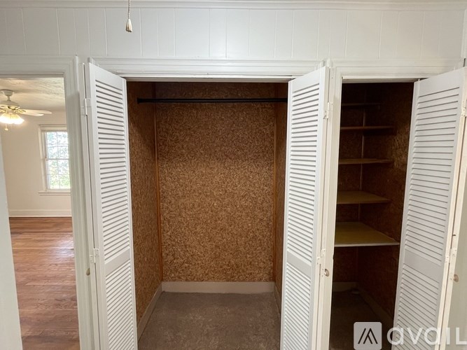 A room with a white door and a brown wallpaper.