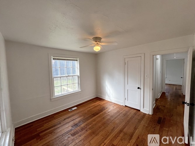 A room with wooden floors and a ceiling fan.