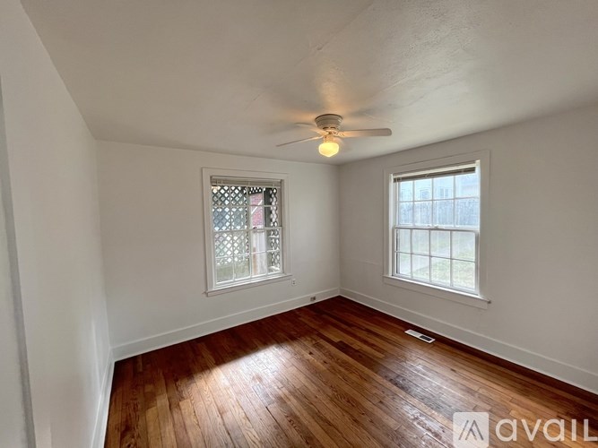 A room with wooden floors and a ceiling fan.