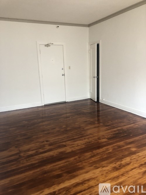 A room with wooden flooring and two doors.