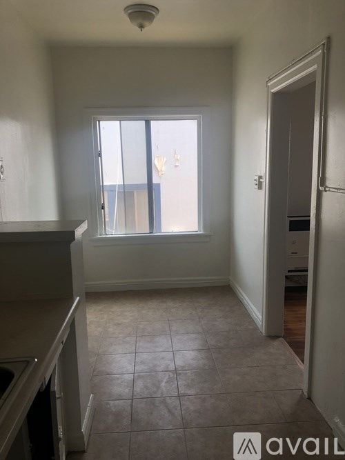 A kitchen with a window and tiled floor.