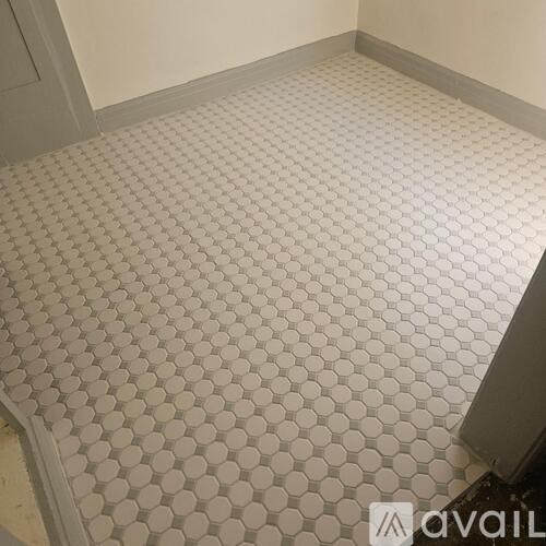A room with a white tiled floor and a grey wall.
