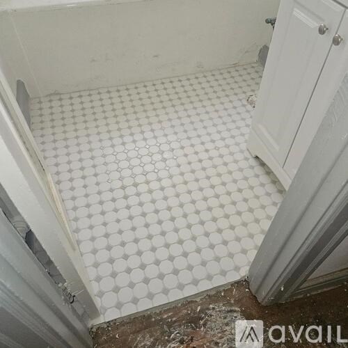 A bathroom with white tiles and a white cabinet.