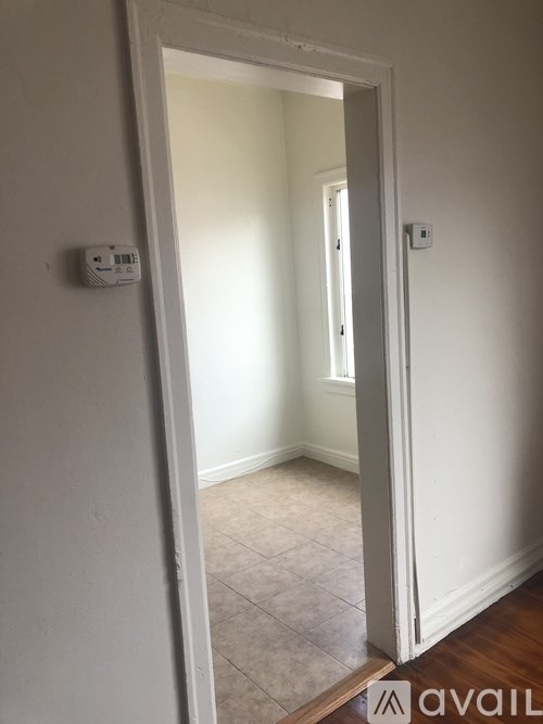 A white door with a wall-mounted thermostat on the wall.