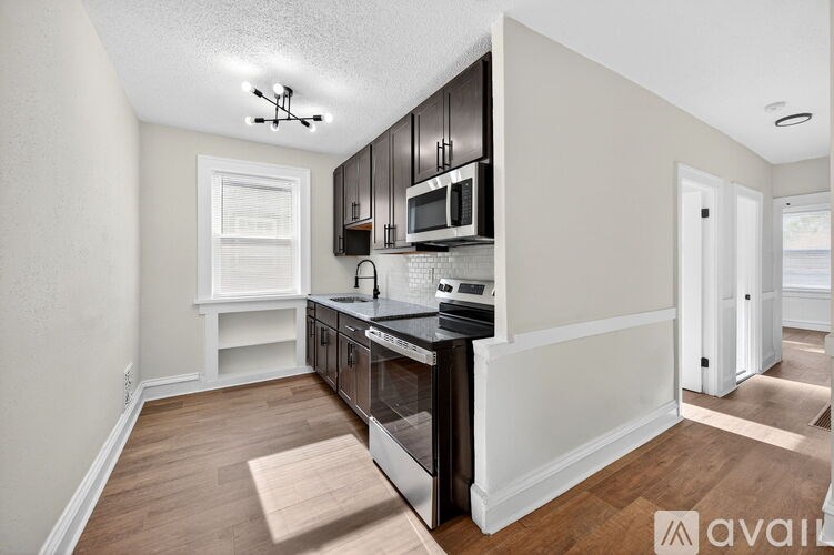 A kitchen with a black counter top and white cabinets.